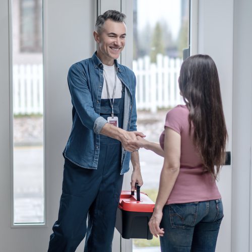 Handwerker begrüßt Kundin an der Haustür
