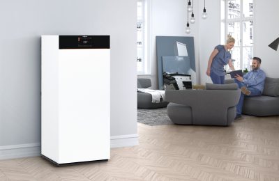 Moderne Heizungsanlage von Viessmann in einem Wohnbereich, während ein Paar auf dem Sofa sitzt