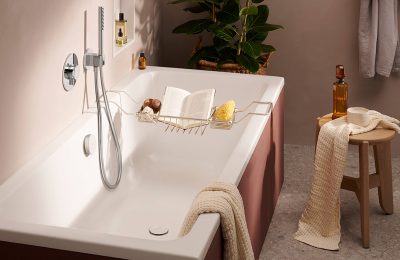 Freistehende Badewanne mit Handbrause, Holzstuhl und Wellness-Accessoires